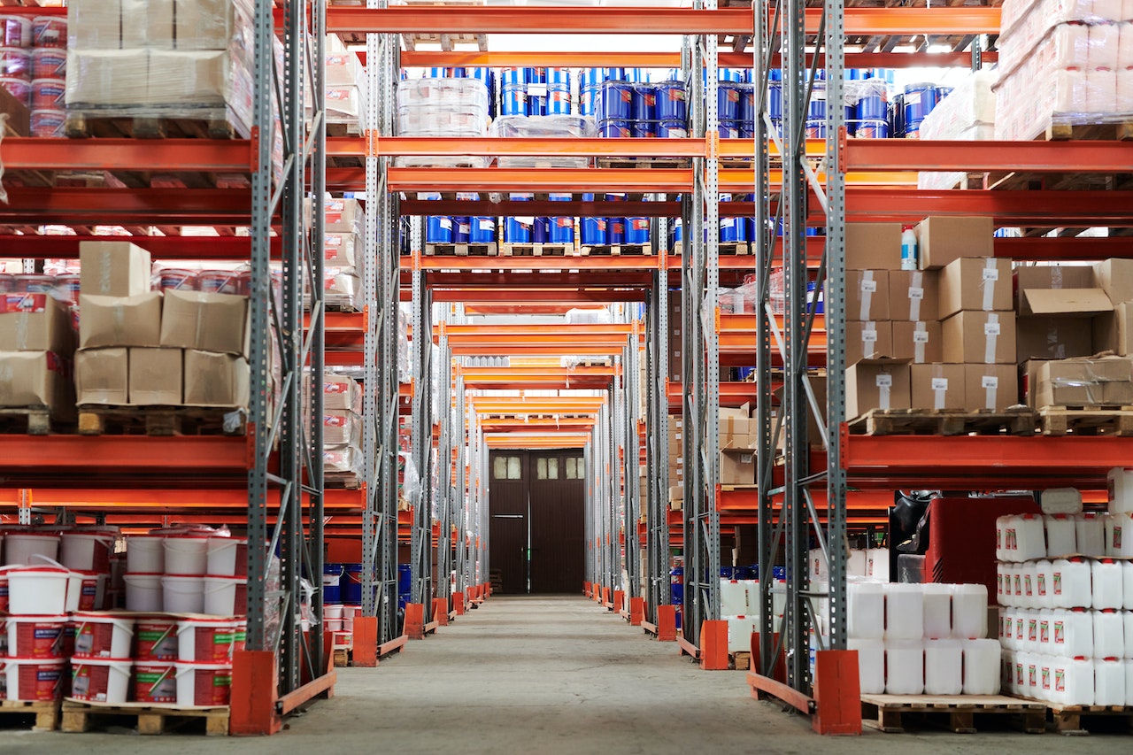 A forklift going down an aisle in a warehouse