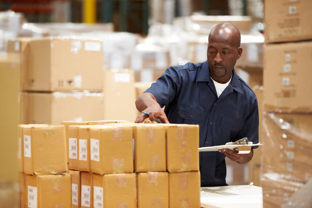 A man checking a shipment waiting to go out.