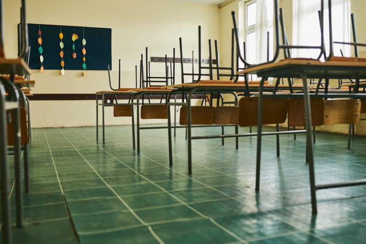 Student desks and chairs within a classroom