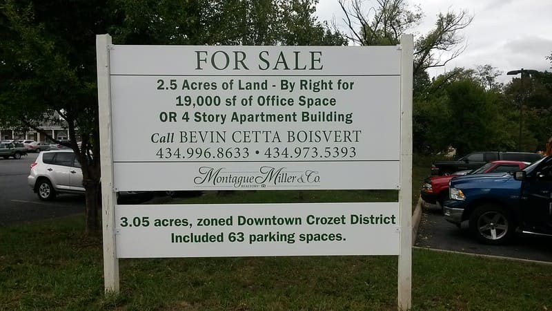 A large wooden property for sale sign